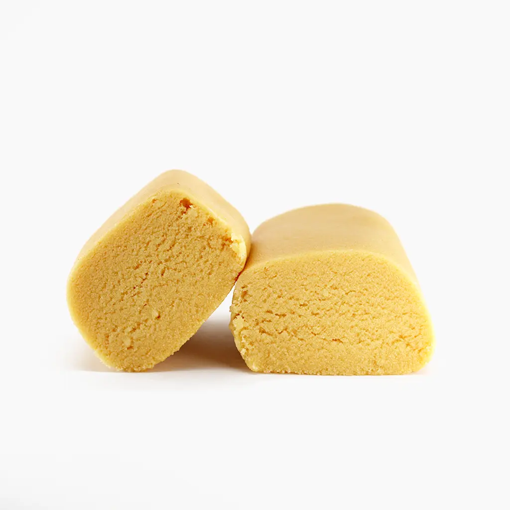 Two pale yellow Piatella pieces with dense, crumbly texture and rounded shape on white background